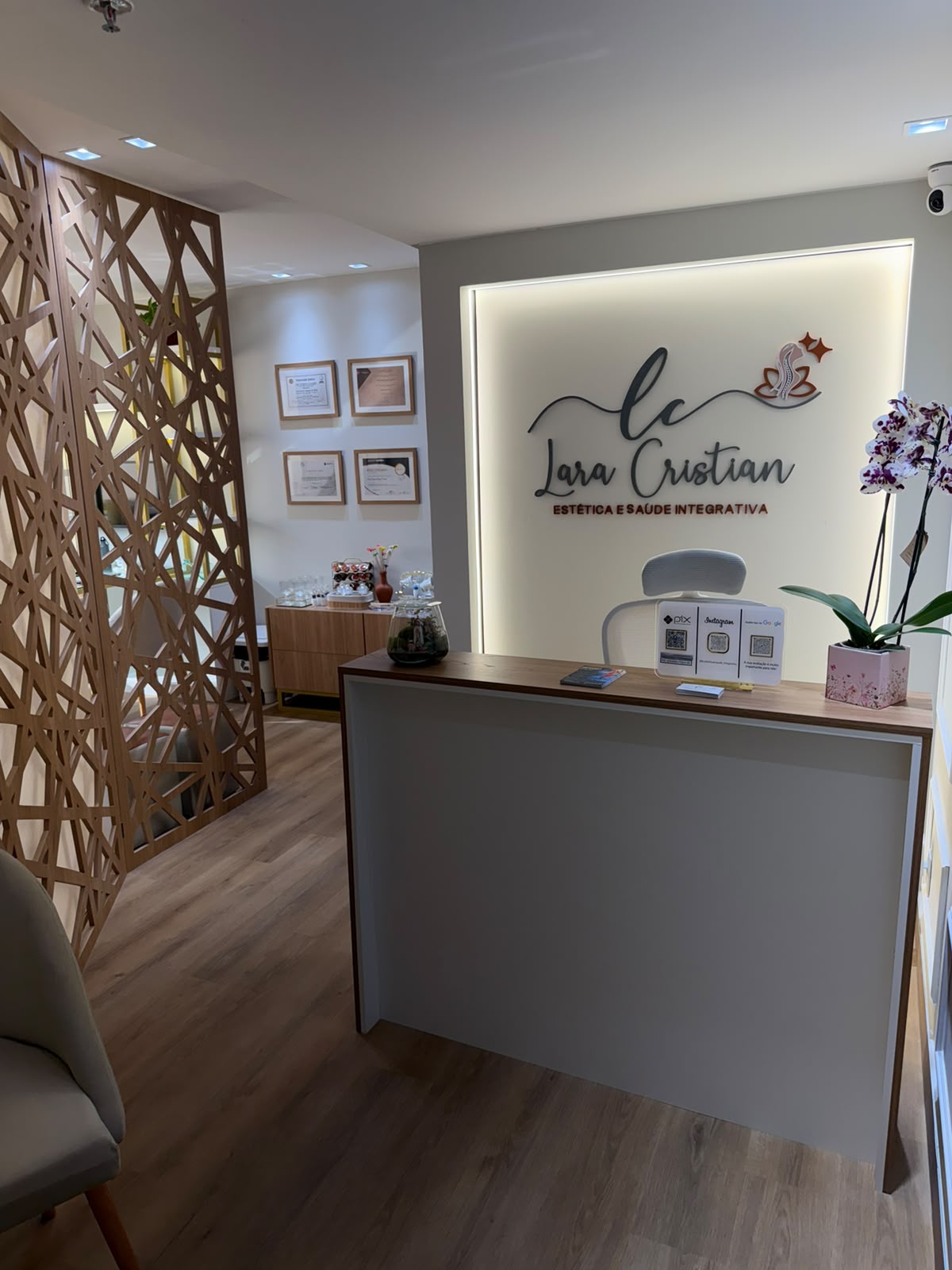 Área de espera com poltronas e capim-dourado — LC Estética, Águas Claras